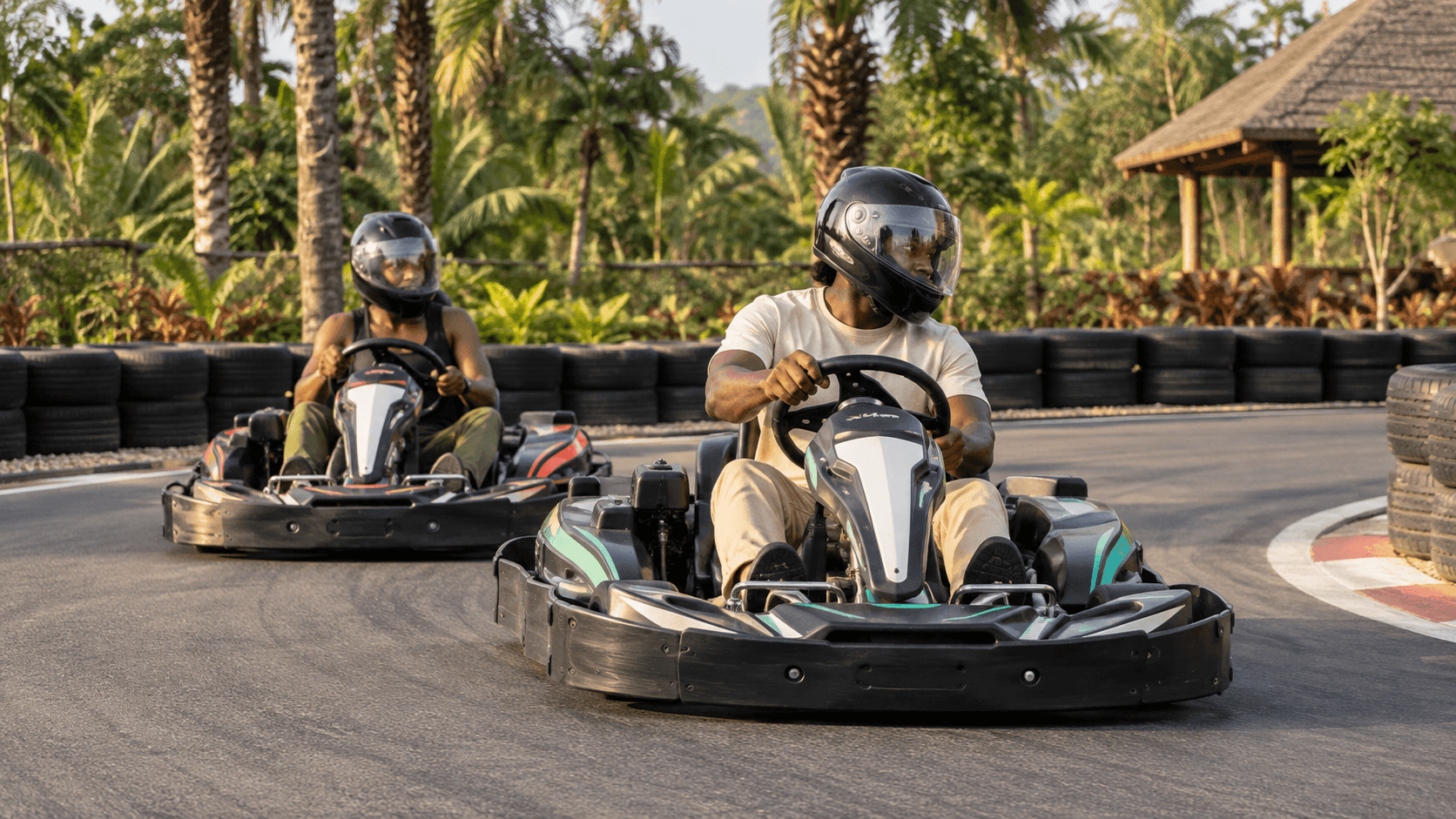 Helmeted drivers on a landscaped outdoor go-kart circuit